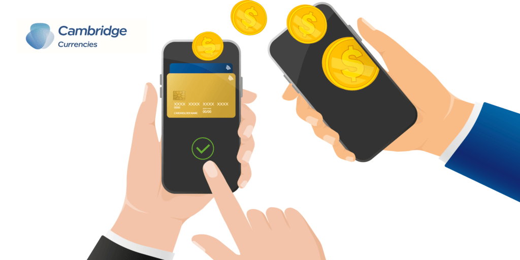 Illustration of a digital money transfer showing two smartphones, one displaying a credit card and the other receiving coins, with the Cambridge Currencies logo in the top left corner. A finger is tapping the screen with a checkmark, symbolizing a successful transaction.