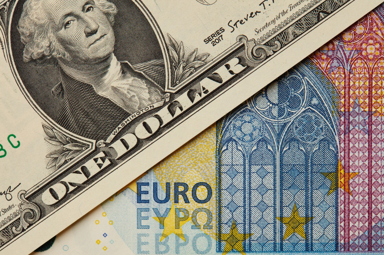 US dollar and euro banknotes representing US retail sales and Eurozone GDP data on February 14, 2025.
